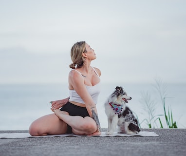 a woman sitting on a rock with a dog