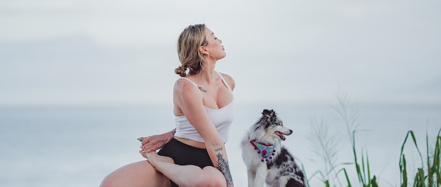 a woman sitting on a rock with a dog
